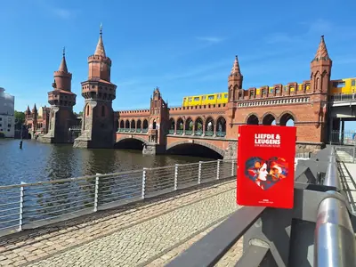 Het boek op een reling met de Oberbaumbrücke en een gele metro erachter.